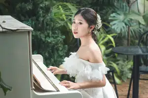 Elegant Bride Plays White Piano Amidst Lush Greenery: A Serene Wedding Moment-4
