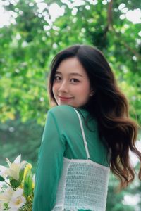 Captivating Smile: Young Woman in Green Embraces Nature's Serenity 1000019864-2