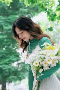 Captivating Smile: Young Woman in Green Embraces Nature's Serenity 1000019864-6