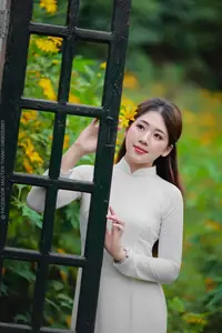 Radiant Youth: Vietnamese Girl in Elegant White Ao Dai Amidst Golden Blooms-2