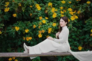 Radiant Youth: Vietnamese Girl in Elegant White Ao Dai Amidst Golden Blooms-8