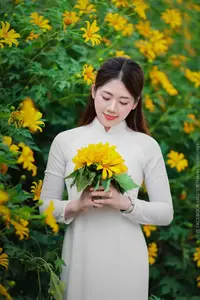 Radiant Youth: Vietnamese Girl in Elegant White Ao Dai Amidst Golden Blooms-3