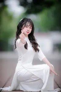 Graceful Vietnamese Girl in Elegant White Ao Dai with Sweet Finger Heart Gesture-0