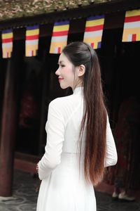 Elegant Vietnamese woman in traditional white Ao Dai, showcasing graceful beauty amidst ancient architecture.-2
