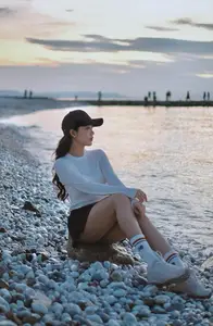 Dreamy Sunset by the Sea: Young Woman Relaxing and Gazing-0
