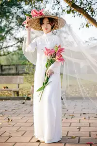 Discover the captivating grace of a Vietnamese woman in a flowing white Ao Dai and traditional conical hat-16