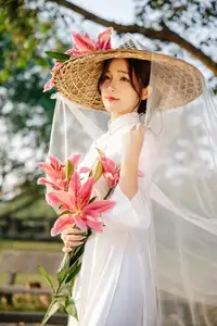 Discover the captivating grace of a Vietnamese woman in a flowing white Ao Dai and traditional conical hat-12