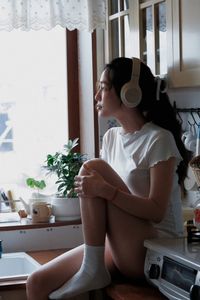 Young Woman Relaxing with Headphones & Music in Cozy Kitchen: Serene Home Lifestyle Moment-15