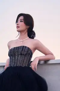 Rooftop Glamour: Elegant Woman Shines in Chic Black Dress, Captivating All Eyes with Effortless Style.-3