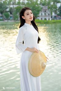 Elegant Vietnamese girl in traditional white Ao Dai by the lake, embodying cultural beauty-6