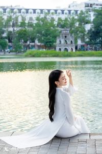 Elegant Vietnamese girl in traditional white Ao Dai by the lake, embodying cultural beauty-4