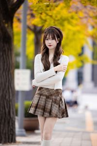 Young Asian Girl in Plaid Skirt Embracing Autumn Foliage-0
