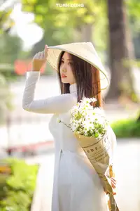 Captivating Beauty: Vietnamese Girl in White Ao Dai with Delicate Daisies.-4