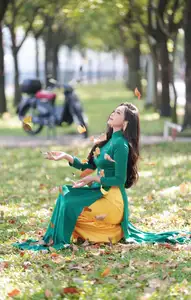 Vietnamese Grace: Elegant Woman in Green Ao Dai with Pink Lotus Flower 1000025232-3