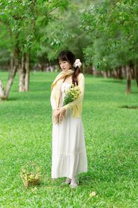 Pure Young Woman with Vibrant Yellow Flowers: Natural Beauty in a Lush Green Setting 1000019709-12
