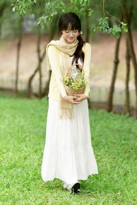Pure Young Woman with Vibrant Yellow Flowers: Natural Beauty in a Lush Green Setting 1000019709-5