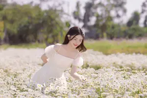 Serene Beauty: Young Woman in White Flower Field, Embracing Tranquility Under Gentle Sunlight-8