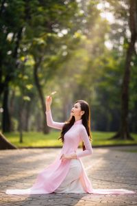 Elegant Vietnamese Woman in Pink Ao Dai Gracing a Sunny Park-4