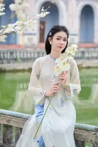 Graceful Ao Dai: The Ethereal Beauty of a Vietnamese Woman with White Orchids, Inspiring Tradition.-2