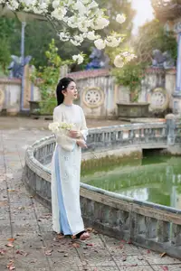 Graceful Ao Dai: The Ethereal Beauty of a Vietnamese Woman with White Orchids, Inspiring Tradition.-6