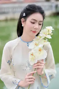 Graceful Ao Dai: The Ethereal Beauty of a Vietnamese Woman with White Orchids, Inspiring Tradition.-0