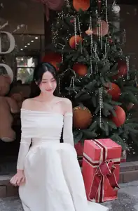 Elegant Girl in Off-Shoulder White Dress Welcoming Christmas, Showcasing Gentle Beauty and Holiday Season Style. 1000027390-5