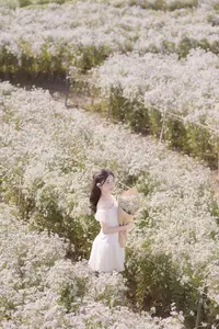 Ethereal Beauty: Young Woman in White Dress with Bouquet Amidst Dreamy Clouds-9