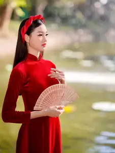Discover the enchanting beauty of a Vietnamese woman in a traditional Red Ao Dai by the tranquil water.-7