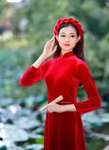 Discover the enchanting beauty of a Vietnamese woman in a traditional Red Ao Dai by the tranquil water.-6