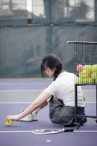 Pensive Break on Court: Young Tennis Player Recharges Energy After Intense Training Session-4