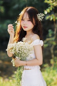 Captivating Portrait: Gentle Girl's Natural Beauty with Pure White Flowers in Golden Sunlight. Discover Her Grace.-0